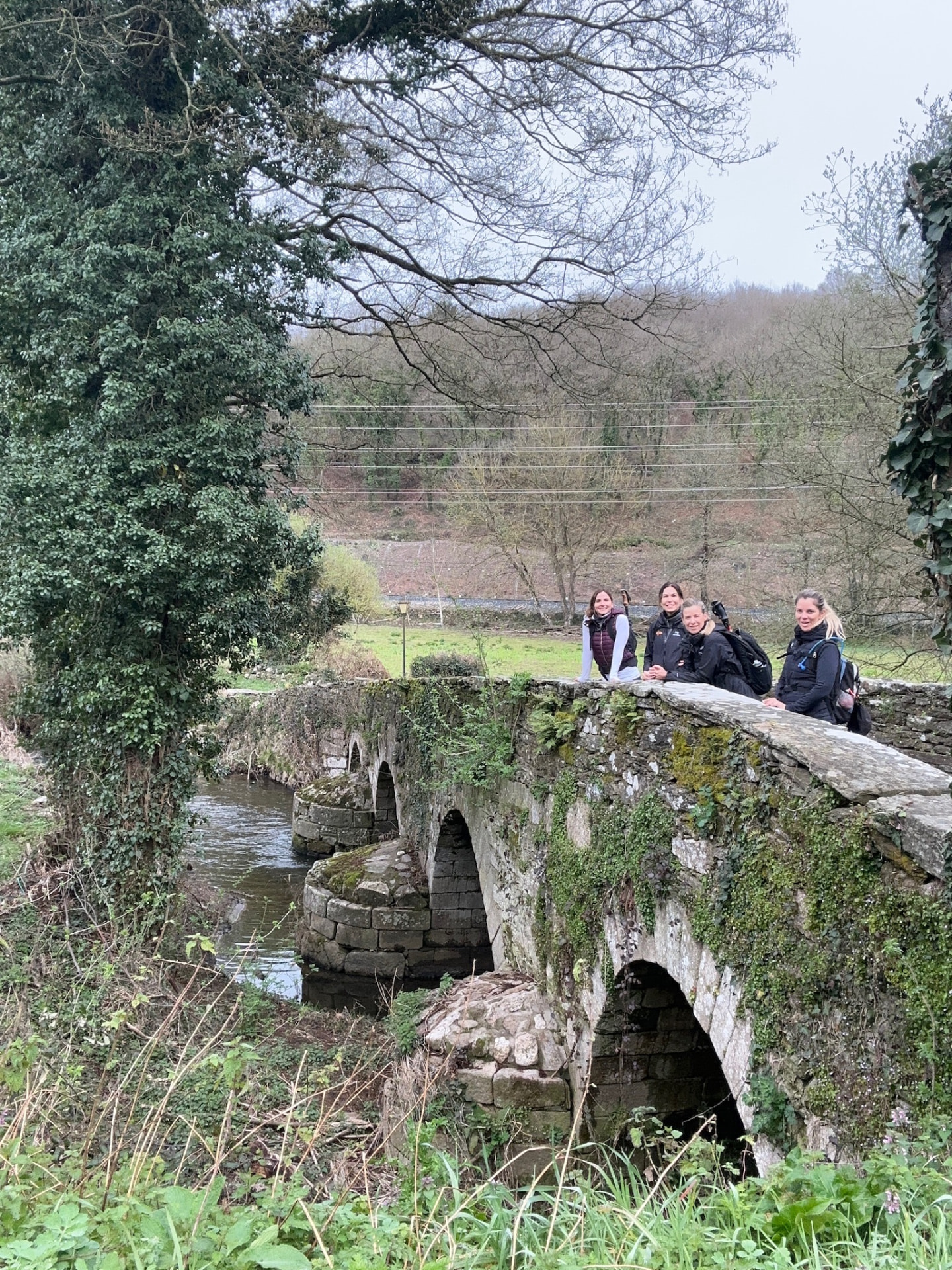 Caminantes del Camino posando sobre un puente de piedra
